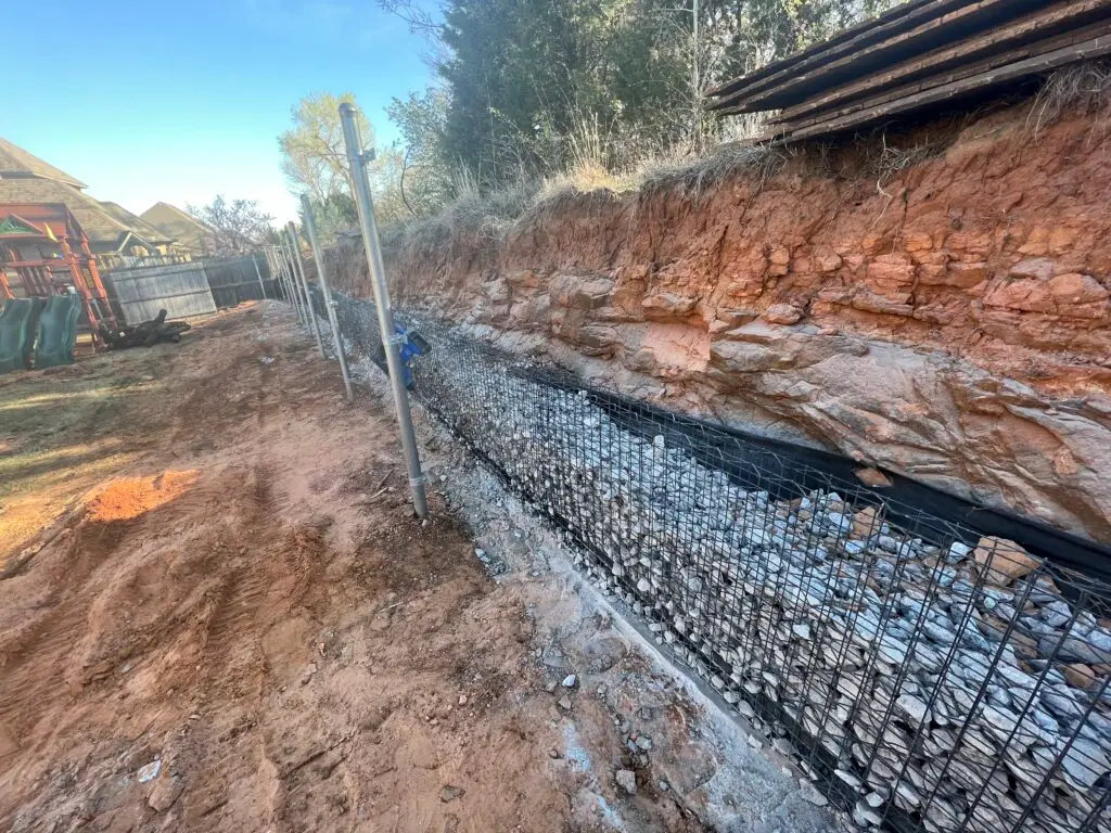 A beautifully designed outdoor hardscape featuring a stone patio, pathway, and seating area under warm ambient lighting.