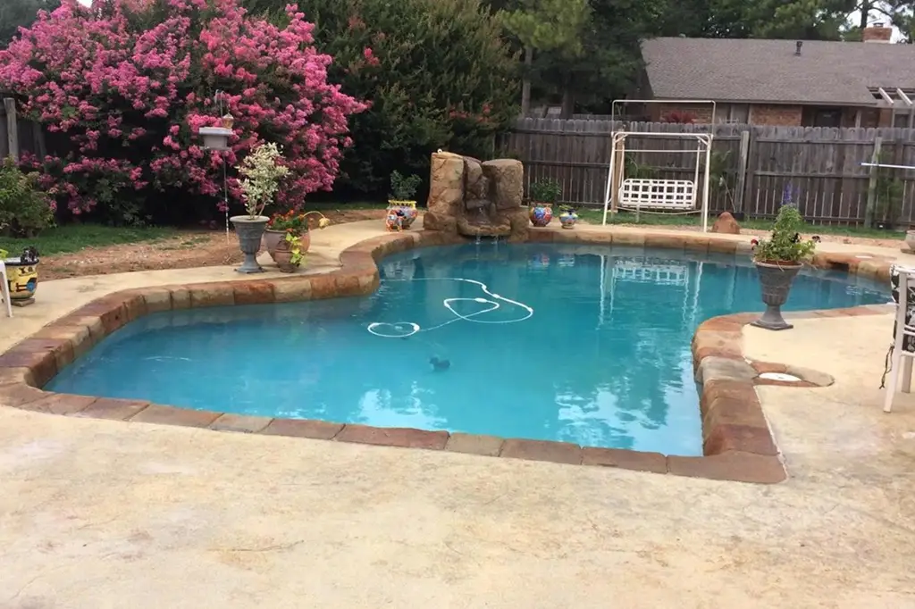 A refreshing green pool under the daylight, with crystal-clear water and a natural outdoor setting.