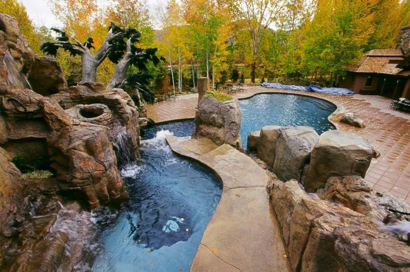 Raised water feature with waterfall and custom sculpture attached to pool Raised water feature with waterfall and custom sculpture attached to pool